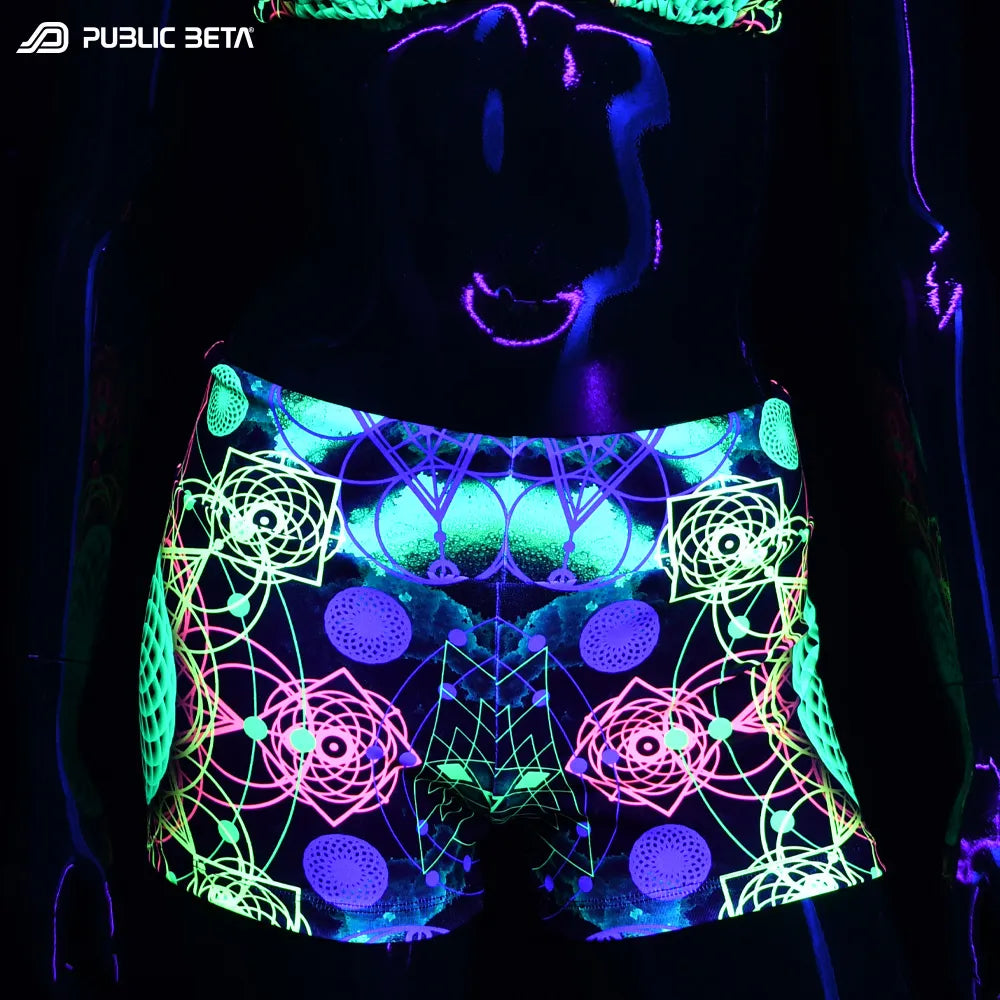Shorts women with UV-reactive psychedelic graphics glowing under blacklight front