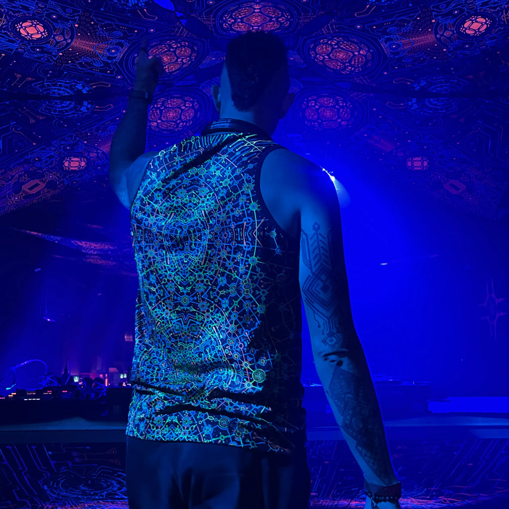 DJ wearing a Sleeveless shirt  with dense pattern UV-reactive graphics glowing under blacklight