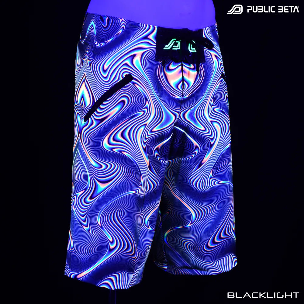 Boardshorts with UV-reactive psychedelic art print glowing under blacklight