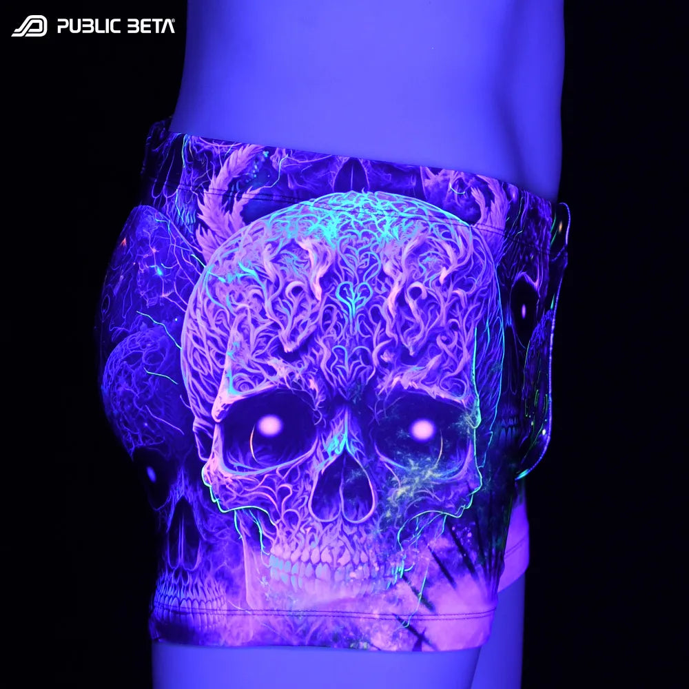 Swim shorts with UV-reactive futuristic print glowing under blacklight
