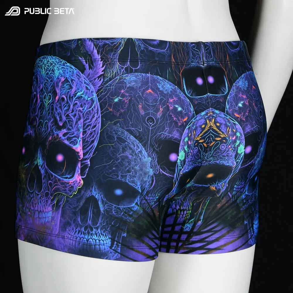 Swim shorts with UV-reactive futuristic graphics, photographed in natural light