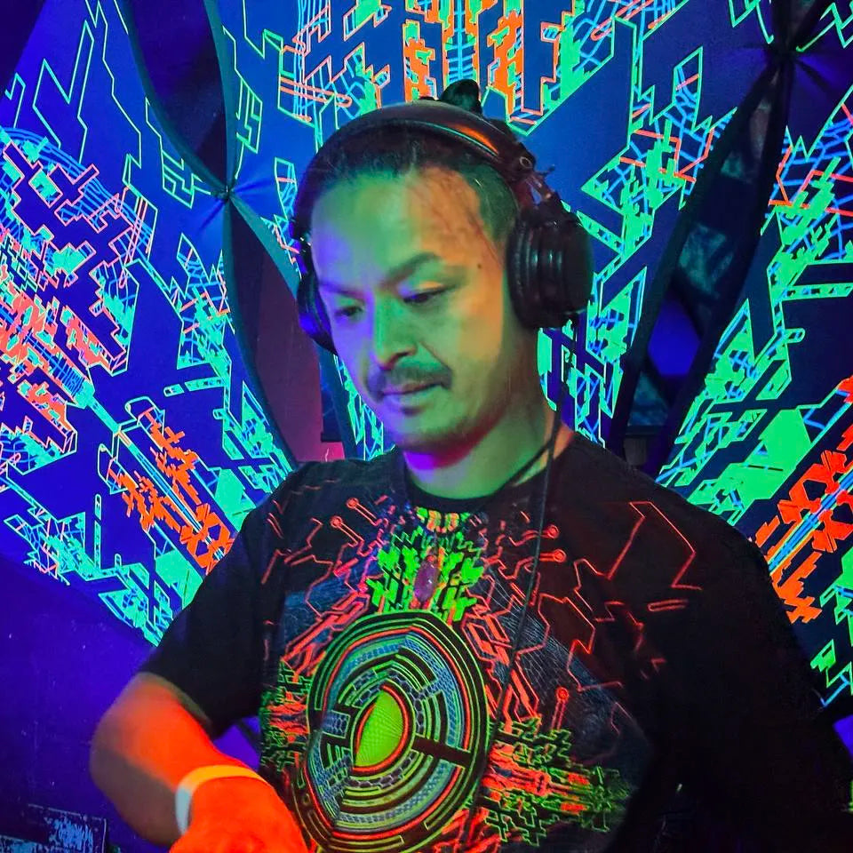 DJ wearing a t-shirt with geometric UV-reactive graphics glowing under blacklight